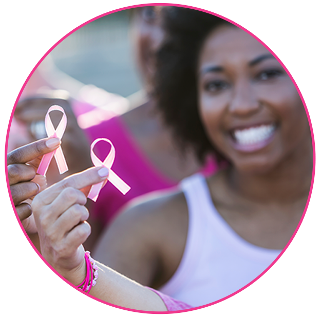 Smiling woman holding pink breast cancer awareness ribbons