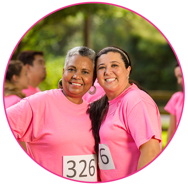Two women in pink shirts at a charity run event